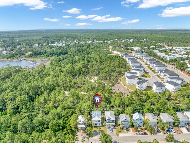 drone / aerial view featuring a residential view, a water view, and a forest view