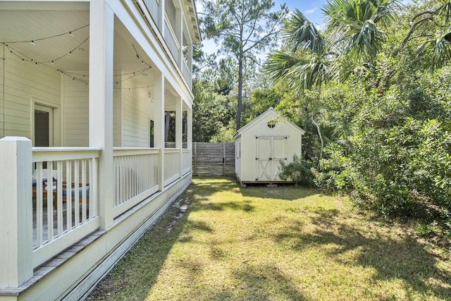 view of yard with an outbuilding, fence, and a shed