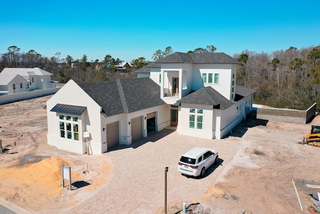 view of front of home featuring a garage, driveway, roof with shingles, and stucco siding