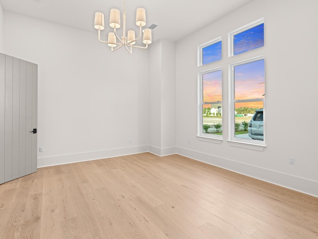 147 Quail Hollow Ct, Watersound, FL 32461 - unfurnished room featuring light wood finished floors, a chandelier, and baseboards