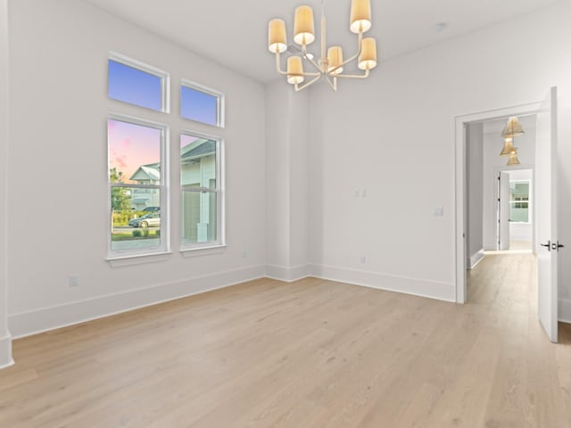147 Quail Hollow Ct, Watersound, FL 32461 - empty room with a chandelier, light wood-type flooring, and baseboards
