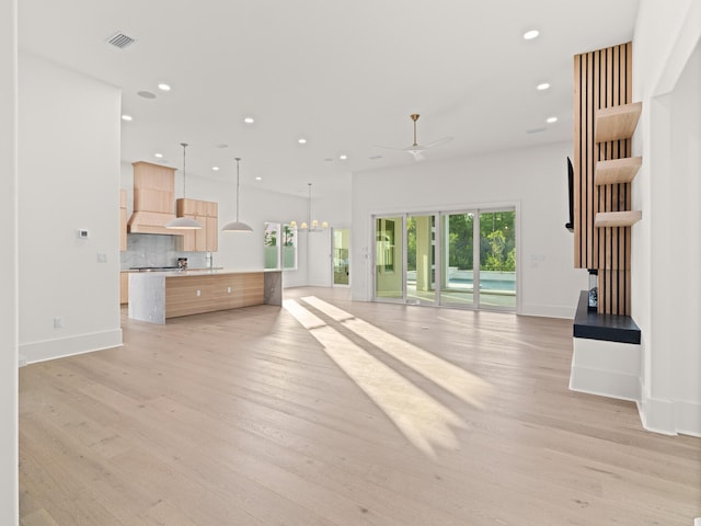 147 Quail Hollow Ct, Watersound, FL 32461 - unfurnished living room with light wood-style floors, ceiling fan, recessed lighting, baseboards, and a chandelier