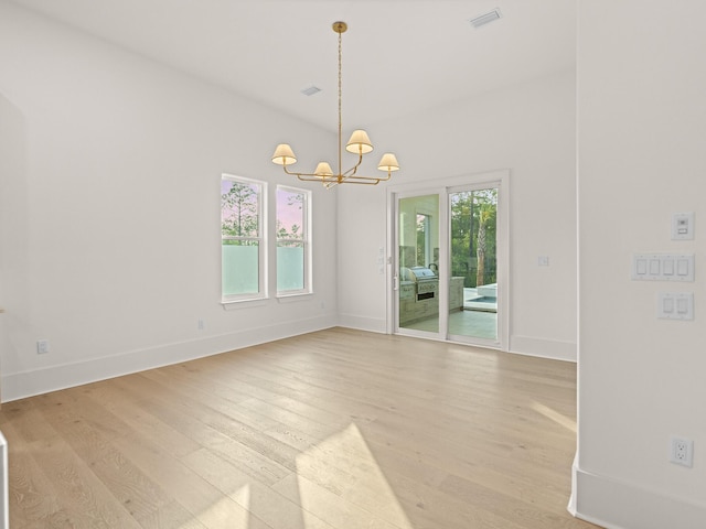 147 Quail Hollow Ct, Watersound, FL 32461 - empty room with a chandelier, light wood-style floors, and baseboards