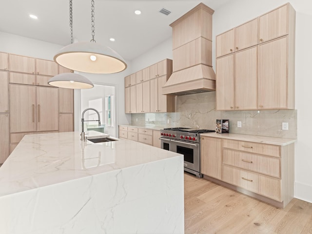 147 Quail Hollow Ct, Watersound, FL 32461 - kitchen featuring designer stove, light brown cabinetry, a sink, custom range hood, and recessed lighting
