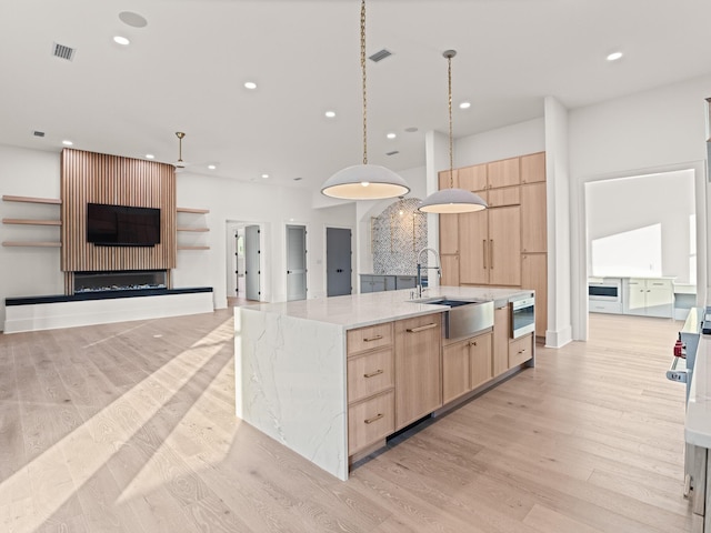 147 Quail Hollow Ct, Watersound, FL 32461 - kitchen featuring light brown cabinetry, modern cabinets, recessed lighting, a sink, and light wood-type flooring