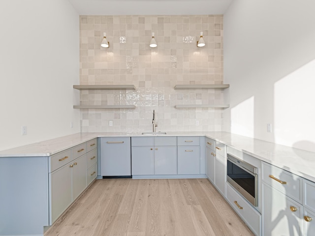 147 Quail Hollow Ct, Watersound, FL 32461 - kitchen with stainless steel microwave, open shelves, a sink, and tasteful backsplash