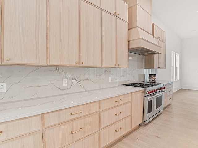 147 Quail Hollow Ct, Watersound, FL 32461 - kitchen with range with two ovens, light brown cabinets, decorative backsplash, and light stone countertops