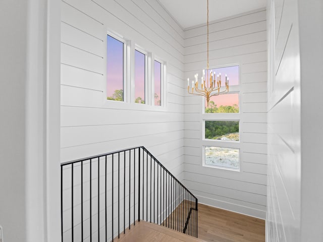 147 Quail Hollow Ct, Watersound, FL 32461 - staircase with a chandelier, wood finished floors, and wood walls