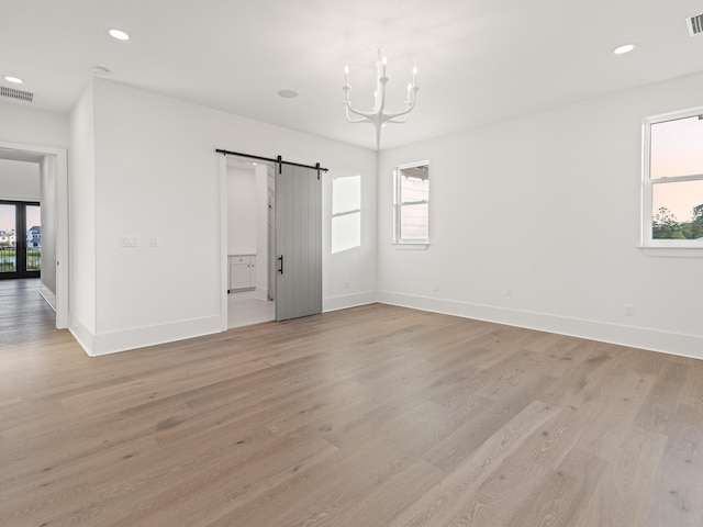 147 Quail Hollow Ct, Watersound, FL 32461 - unfurnished bedroom featuring a barn door, a chandelier, light wood-style flooring, baseboards, and recessed lighting