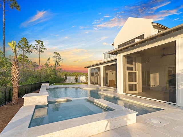 147 Quail Hollow Ct, Watersound, FL 32461 - pool at dusk featuring a patio, a fenced backyard, a pool with connected hot tub, and ceiling fan