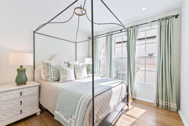 bedroom featuring multiple windows, baseboards, wood finished floors, and recessed lighting