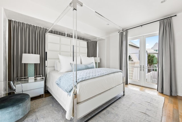 bedroom with french doors, wood finished floors, and access to exterior