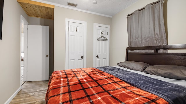 bedroom with light hardwood / wood-style flooring and a textured ceiling