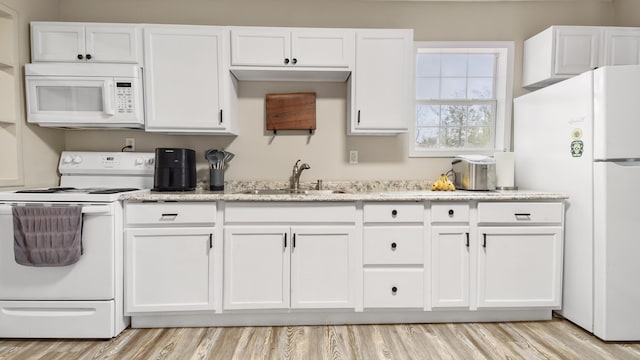 kitchen with white cabinetry, sink, white appliances, and light stone countertops