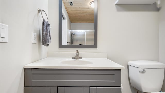 bathroom featuring a shower with door, vanity, wooden ceiling, and toilet