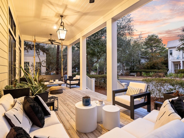 patio terrace at dusk with ceiling fan and an outdoor living space