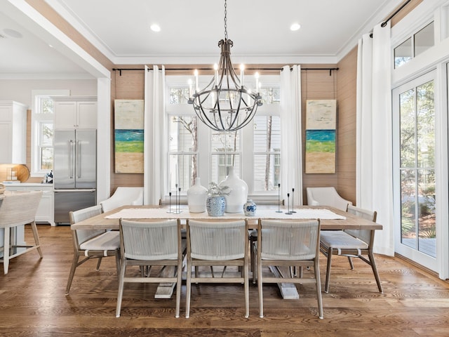 dining area with plenty of natural light, ornamental molding, and wood finished floors