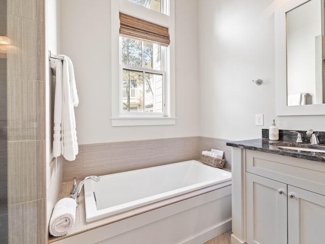 bathroom featuring a tub to relax in and vanity