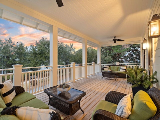 wooden terrace with a ceiling fan and outdoor lounge area