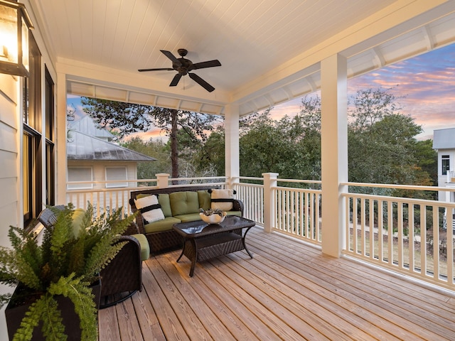 wooden terrace with a ceiling fan and outdoor lounge area