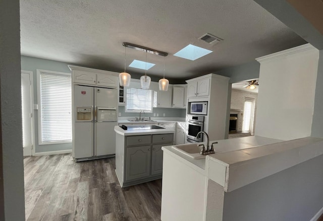 kitchen with hanging light fixtures, a center island, white cabinets, and white appliances