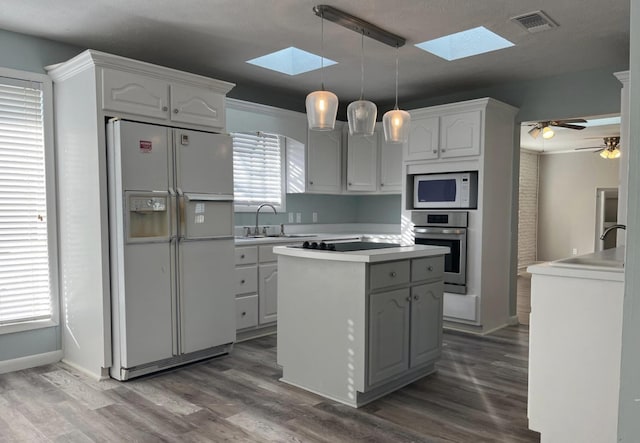 kitchen with white appliances, decorative light fixtures, sink, and white cabinets