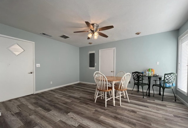 dining area featuring a textured ceiling, electric panel, dark hardwood / wood-style floors, and ceiling fan