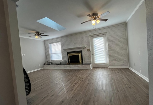 unfurnished living room featuring crown molding, a fireplace, dark wood-type flooring, and brick wall