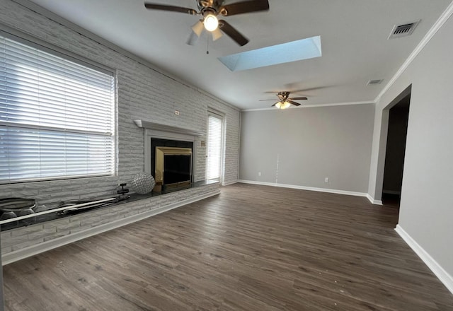 unfurnished living room featuring a fireplace, dark wood-type flooring, a skylight, and ornamental molding