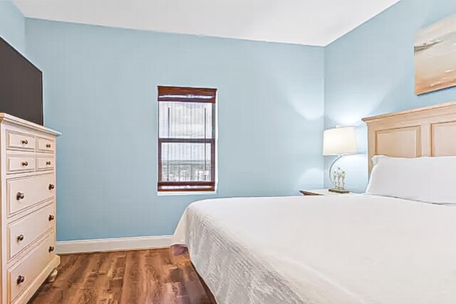 9860 S Thomas Dr Unit 921, Panama City Beach, FL 32408 - bedroom featuring baseboards and dark wood-type flooring