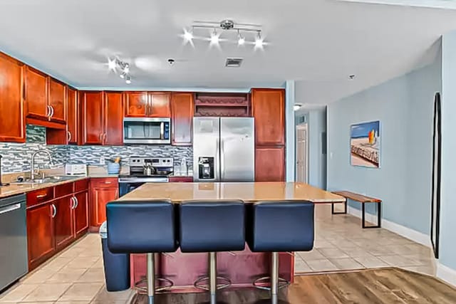 9860 S Thomas Dr Unit 921, Panama City Beach, FL 32408 - kitchen featuring stainless steel appliances, a center island, visible vents, and decorative backsplash