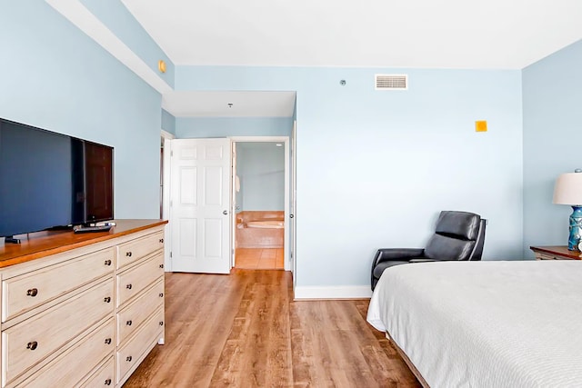 bedroom with baseboards, visible vents, and light wood-style floors