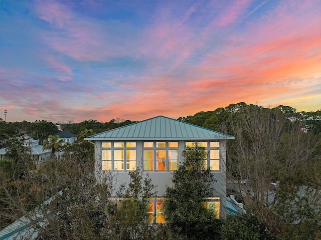 exterior space with a standing seam roof, metal roof, and stucco siding