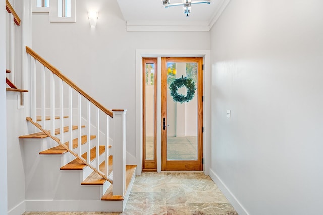 entrance foyer featuring stairway, baseboards, and ornamental molding