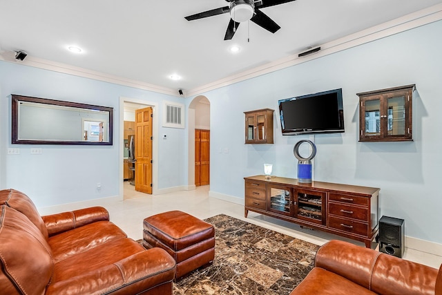 living area with baseboards, visible vents, arched walkways, a ceiling fan, and crown molding