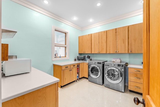 clothes washing area featuring a toaster, crown molding, washing machine and clothes dryer, recessed lighting, and cabinet space