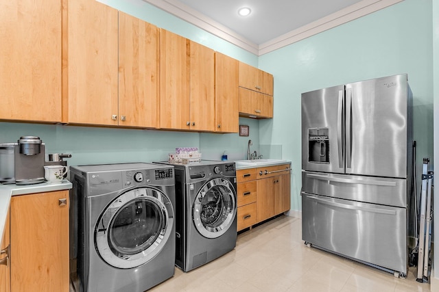 laundry area with laundry area, ornamental molding, washer and clothes dryer, and a sink