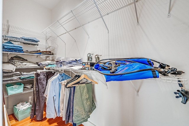 walk in closet with wood finished floors