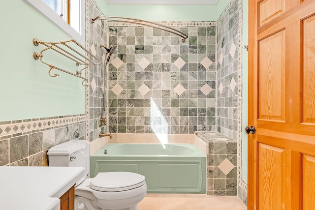 bathroom with toilet, bathing tub / shower combination, vanity, and tile walls