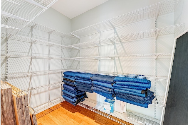 walk in closet with wood finished floors