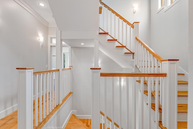 staircase featuring crown molding, recessed lighting, wood finished floors, and baseboards