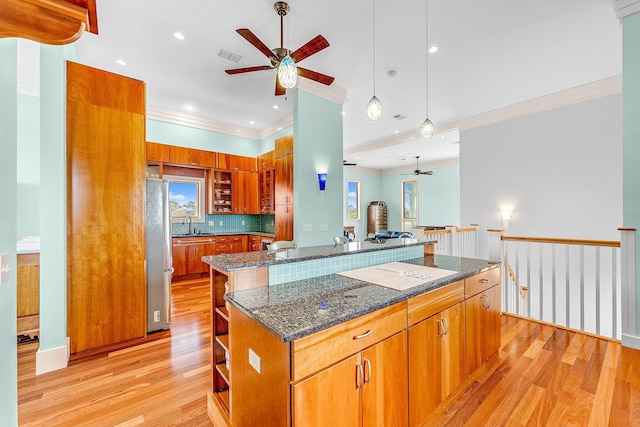 kitchen with open shelves, light wood finished floors, brown cabinetry, and freestanding refrigerator