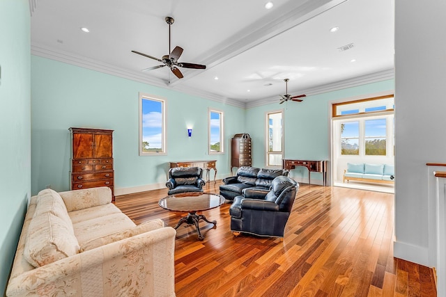 living area with ornamental molding, visible vents, baseboards, and wood finished floors