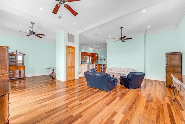 living area with light wood finished floors, visible vents, and crown molding