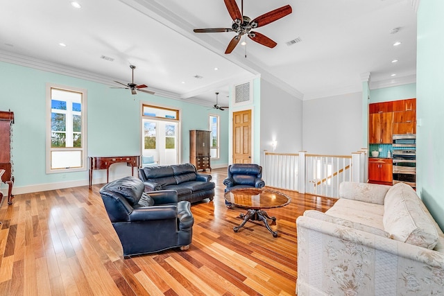 living room featuring light wood-style floors, baseboards, visible vents, and crown molding