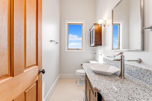 bathroom with toilet, baseboards, and vanity