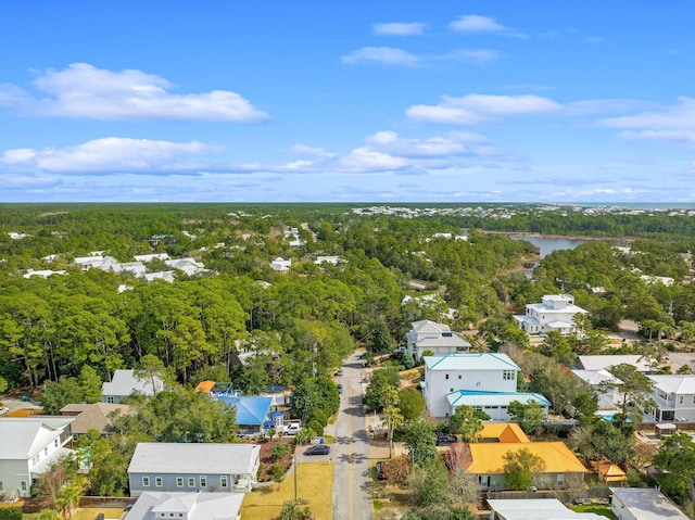 drone / aerial view featuring a water view, a forest view, and a residential view