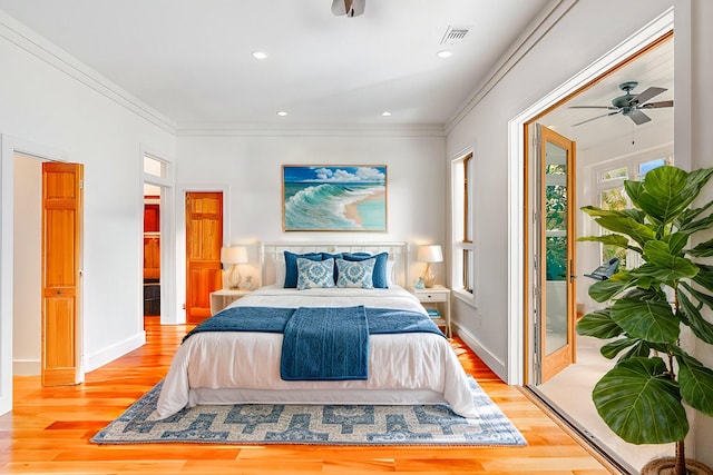 bedroom featuring ornamental molding, light wood-type flooring, visible vents, and multiple windows