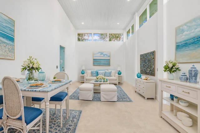 living area with finished concrete flooring, a high ceiling, and recessed lighting