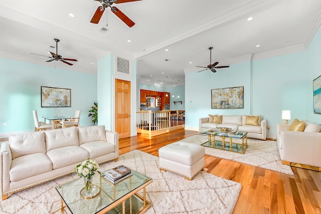 living room featuring visible vents, wood finished floors, and ornamental molding